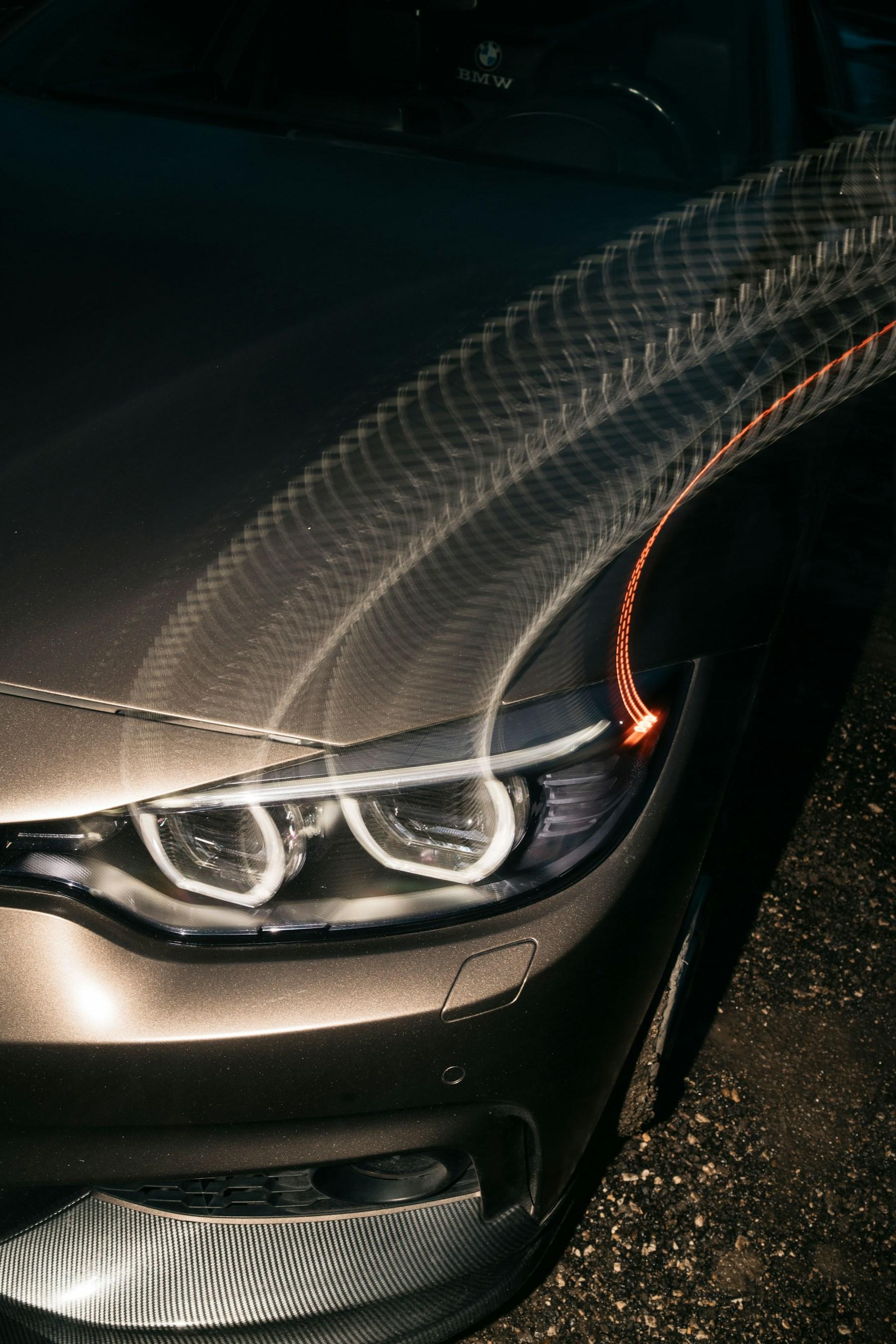 Close-up of silver car bodywork and a headlight assembly